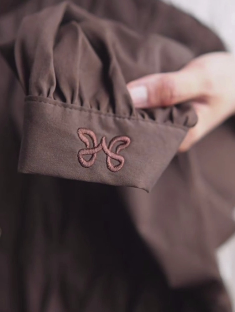 Embroidered Wadi Adra monogram on cocoa fabric cuff