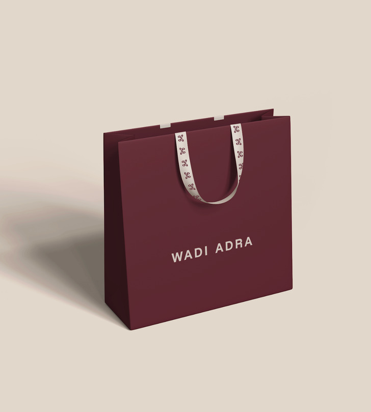 Wadi Adra maroon shopping bag with monogram ribbon handles
